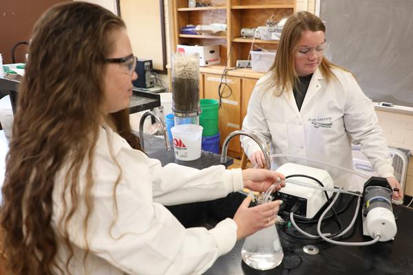 Two female students using environmental engineering lab equipment